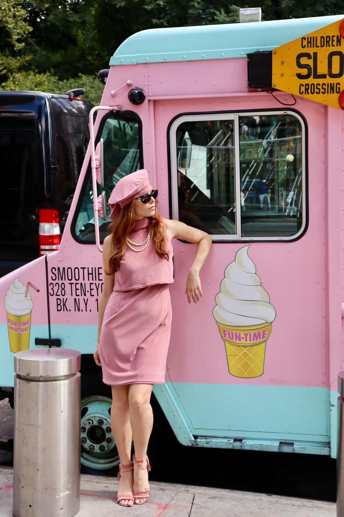 Our model looking cool as ice cream, sporting our strawberry shake, sleeveless dress, and matching beret. Styled with black sunglasses, a classic pearl necklace and pink heels.
