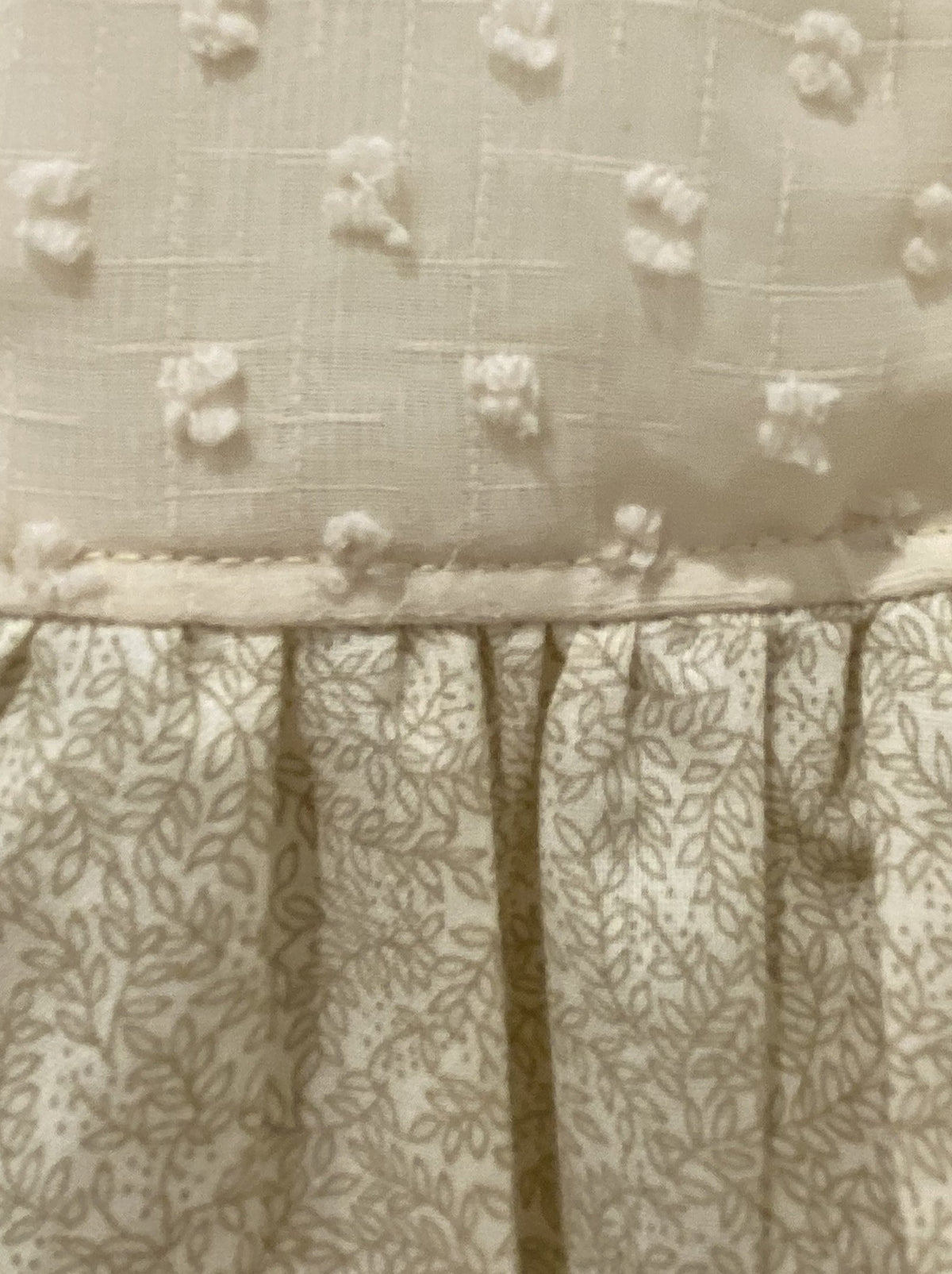 Close up of Model wearing cream cotton Swiss Dot and Cailco fabric.