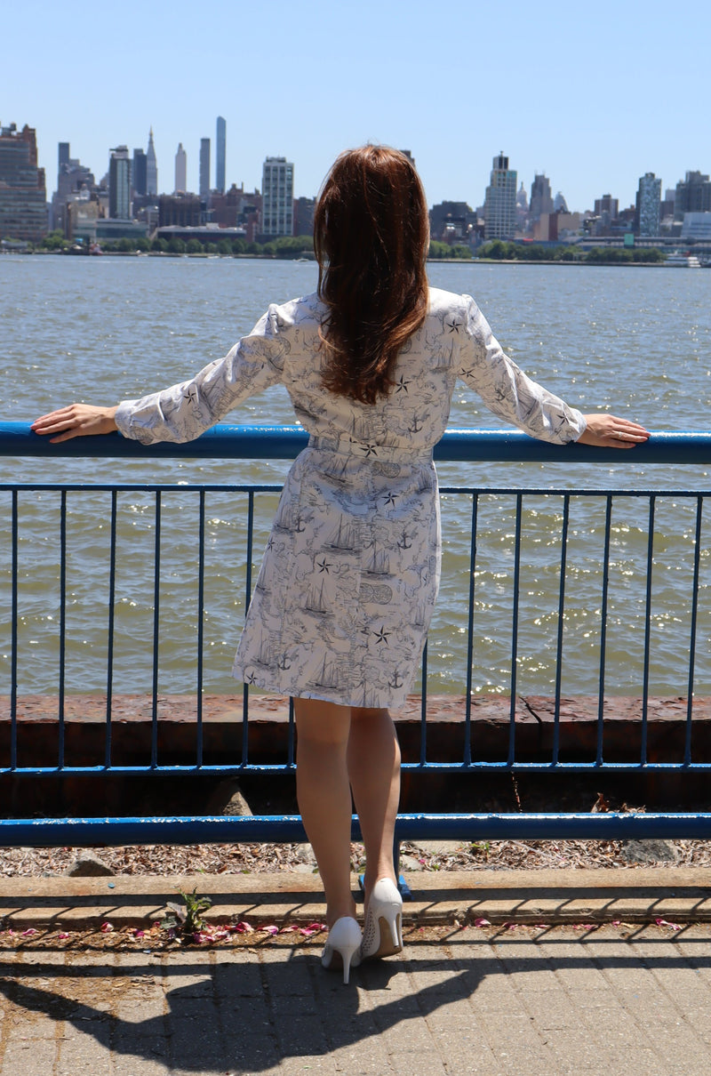 Back of model wearing a nautical cotton print long sleeve shirtdress.