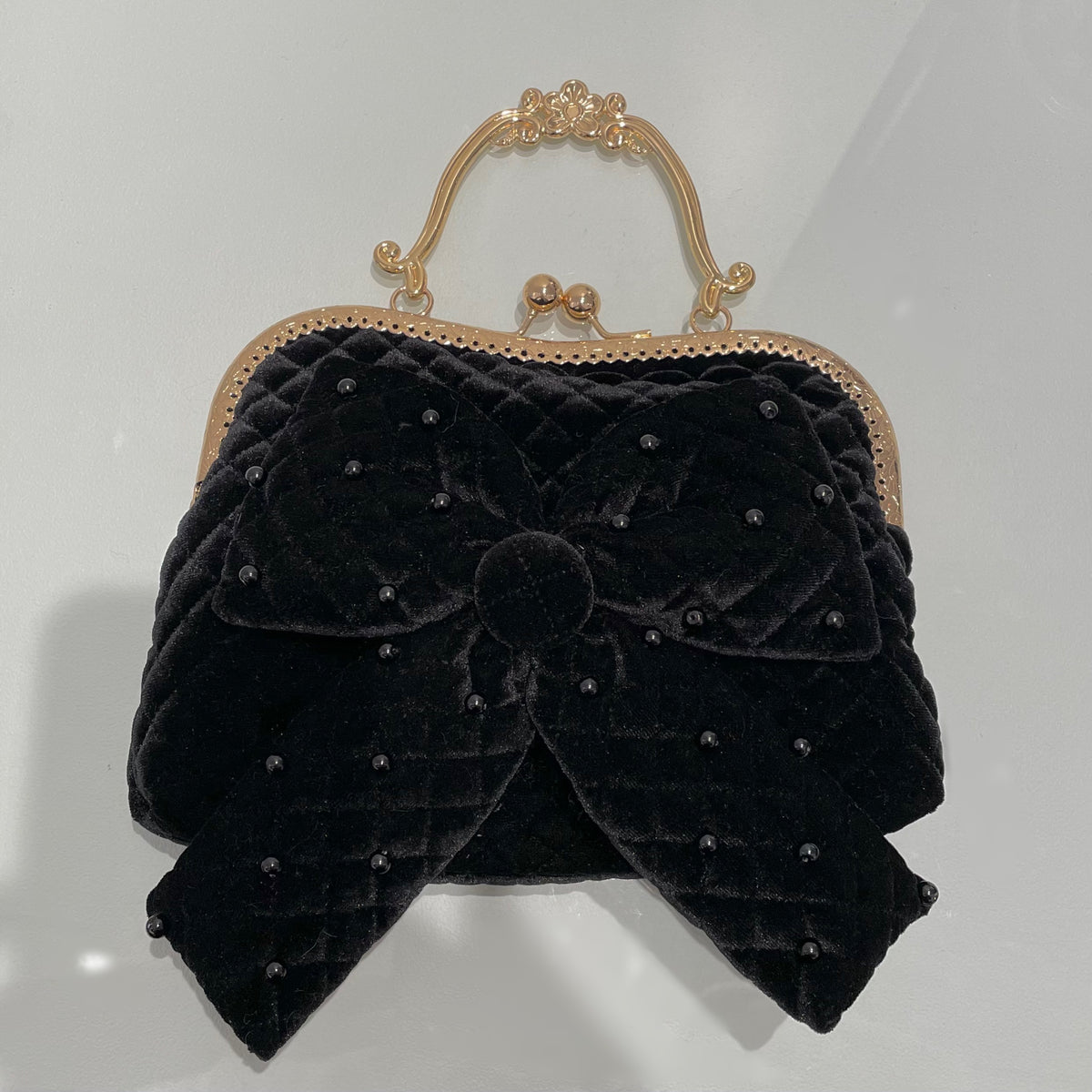 Our classic little black purse with velvet exterior a beautiful bow and spots that shine to add a level of sophistication to any outfit