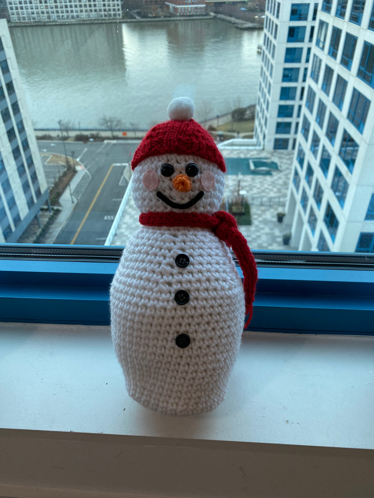 Cute crocheted snowman with a red beanie and red scarf