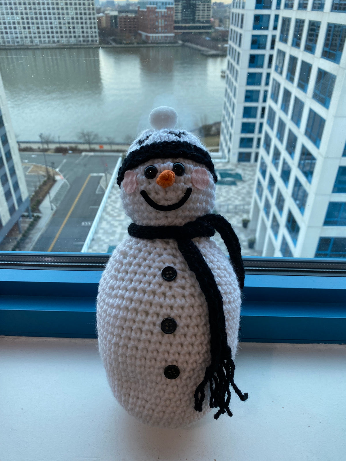 Cute crocheted snowman with white beanie featuring Black hearts and a plain black scarf