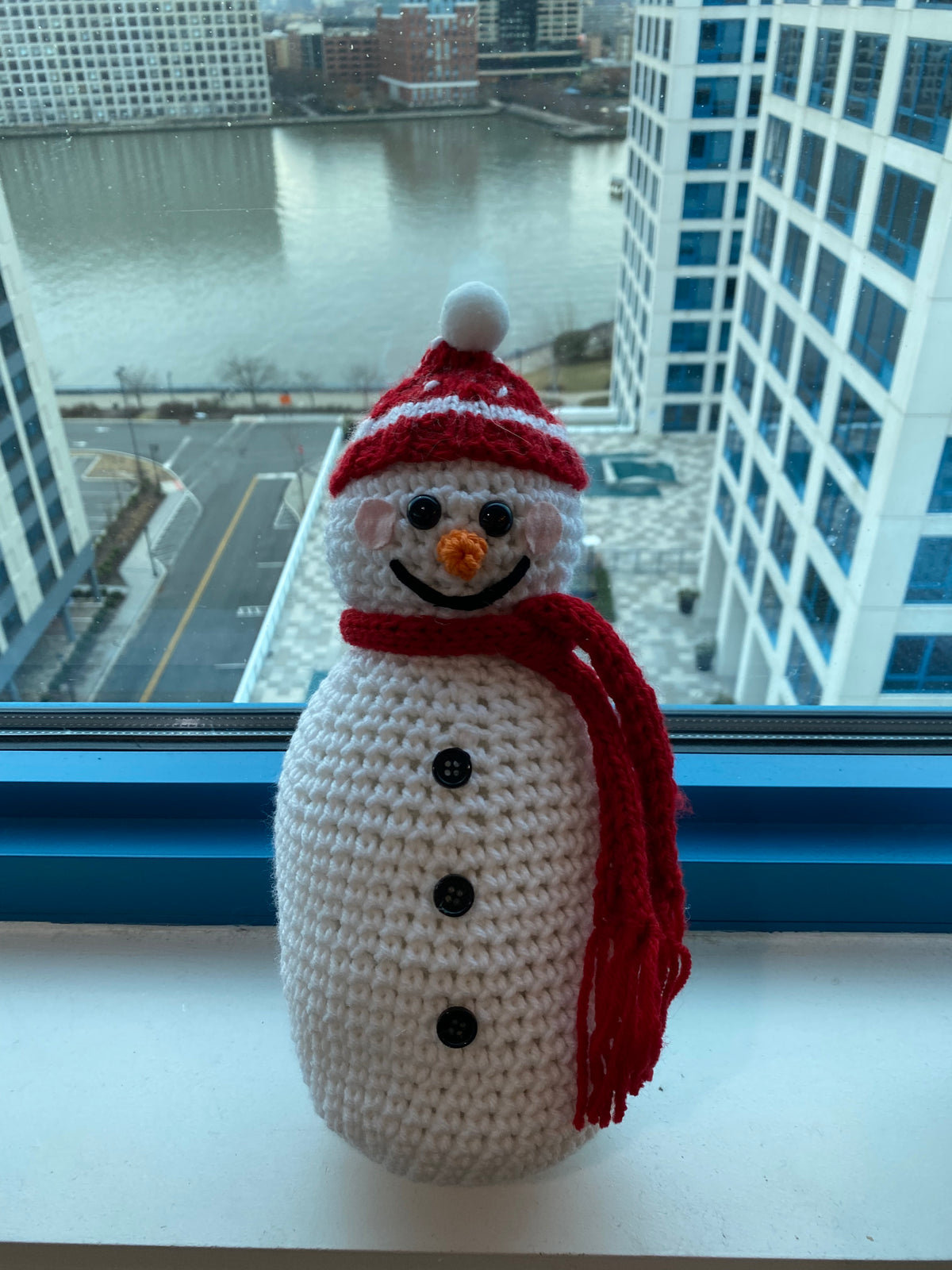Cute crocheted snowman with red and white beanie and red scarf