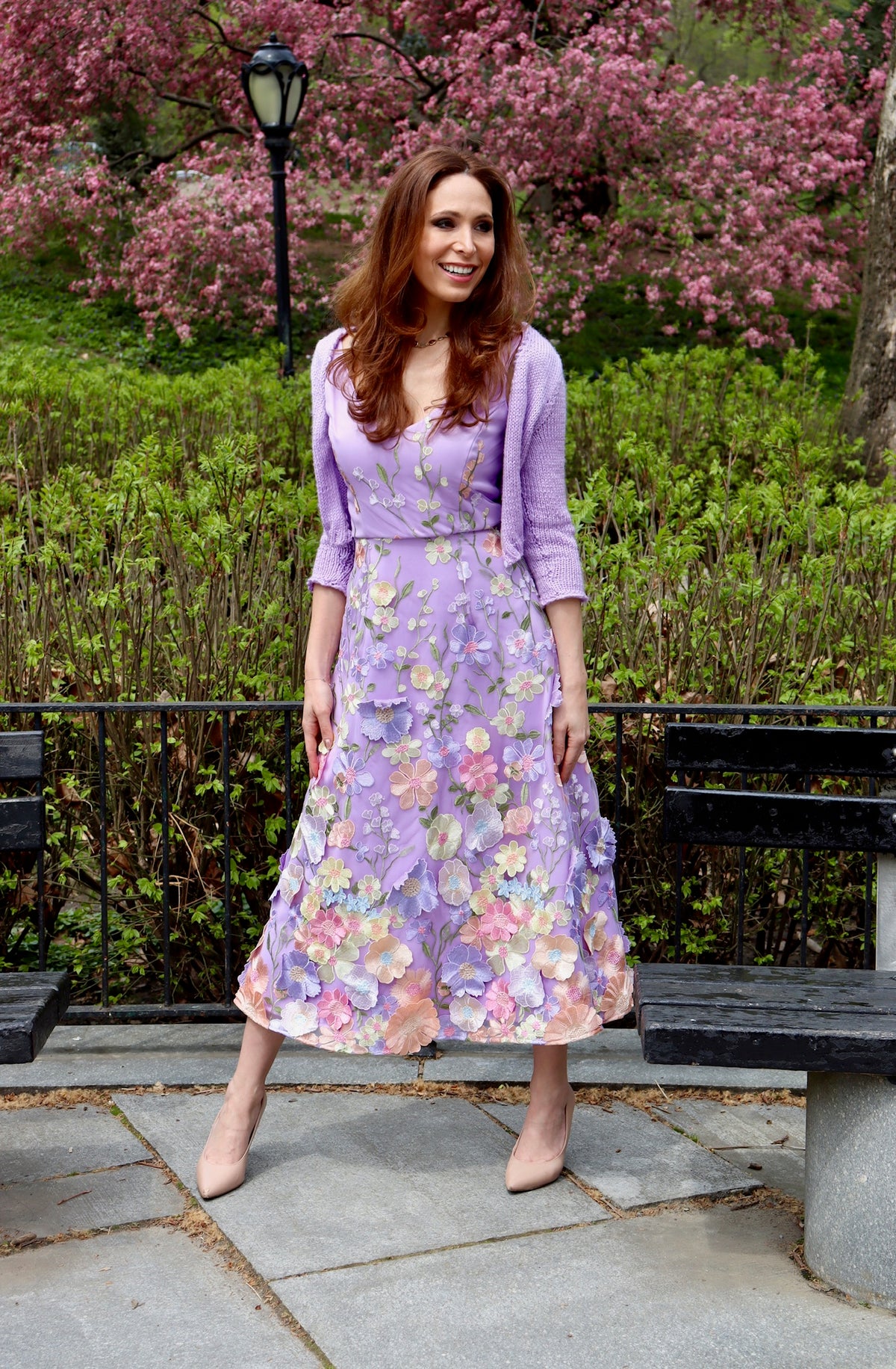 Model in lilac midi length appliquéd floral detailed dress with matching lilac cropped knitted sweater.