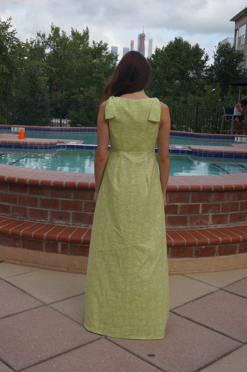 Back of model wearing a light green maxi dress.