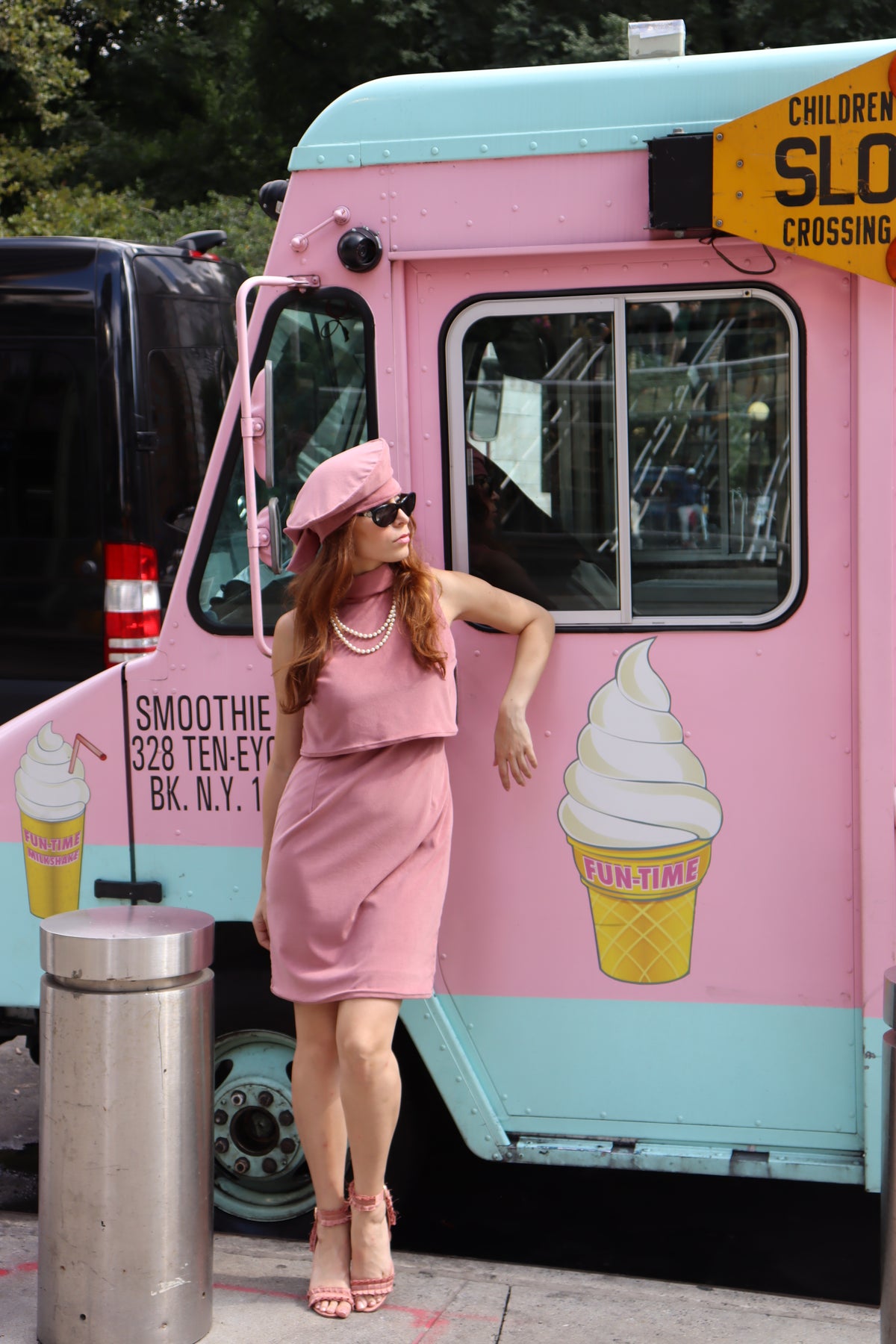 Our model looking cool as ice cream, sporting our strawberry shake, sleeveless dress, and matching beret. Styled with black sunglasses, a classic pearl necklace and pink heels.