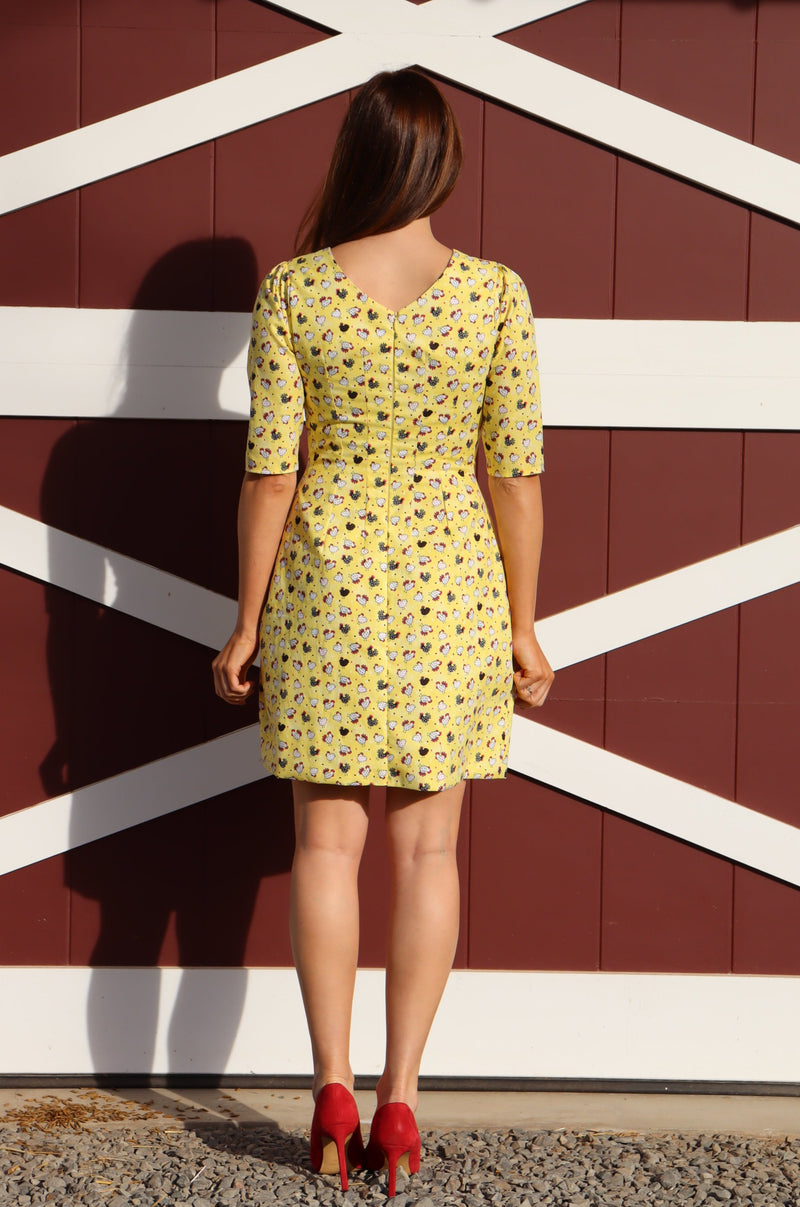 Back view of Model wearing Editorial Chicken Dress,  a cute chicken print classic shift dress.
